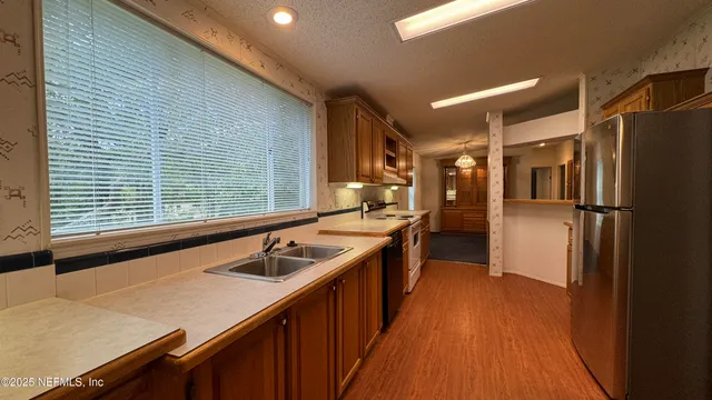 a kitchen with stainless steel appliances granite countertop a sink and wooden cabinets