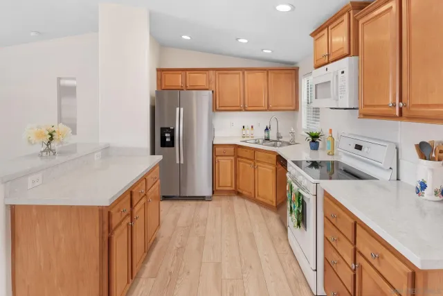 a kitchen with a sink a refrigerator and cabinets