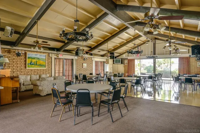 a view of a big room with dining table chairs and a table