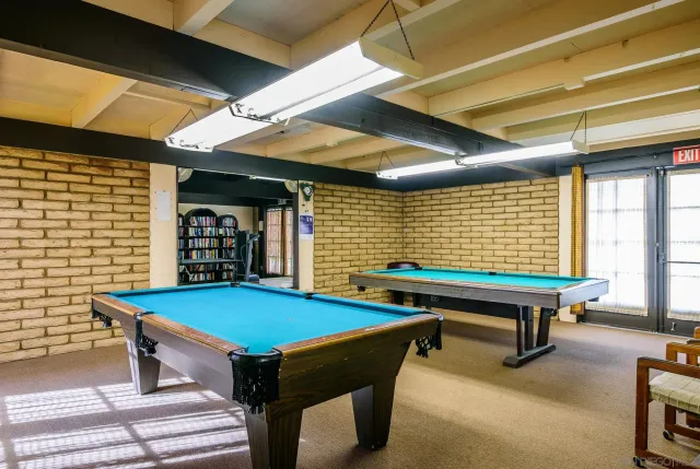 a room with pool table and windows