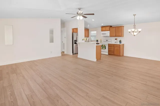 a view of a kitchen with a sink dishwasher a kitchen view with wooden floor and a large window