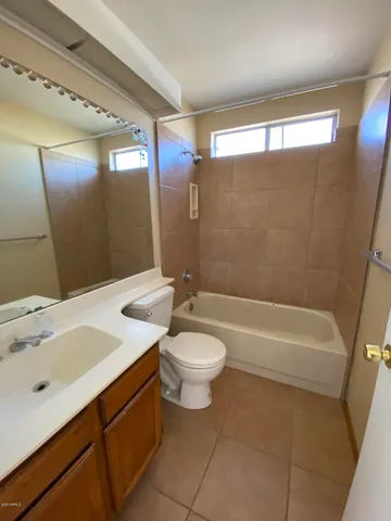 a bathroom with a sink a toilet a mirror and bathtub