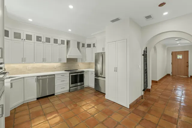 a kitchen with granite countertop a sink cabinets and stainless steel appliances