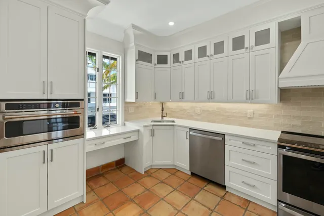 a kitchen with granite countertop white cabinets and white appliances