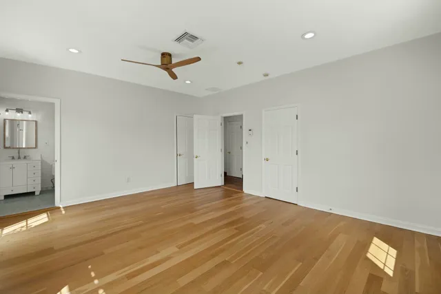 a bathroom with a granite countertop toilet sink shower and mirror