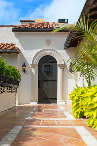 a view of a grey house with a garage and a chair