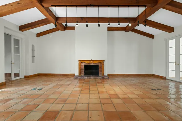 a view of empty room with wooden floor and fireplace