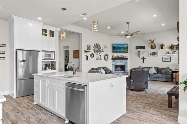 a kitchen with stainless steel appliances granite countertop a refrigerator and a stove top oven