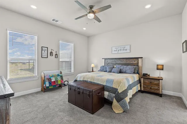 a spacious bedroom with a bed and a ceiling fan