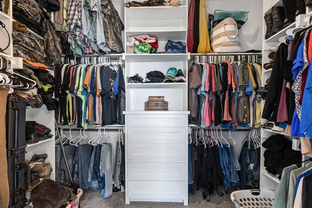 a view of walk in closet with clothes and shoes