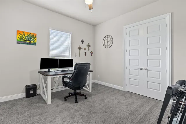 a view of a workspace with furniture and a window