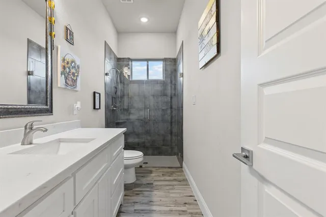 a bathroom with a sink a toilet and shower