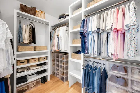 a view of walk in closet with clothes and shoes