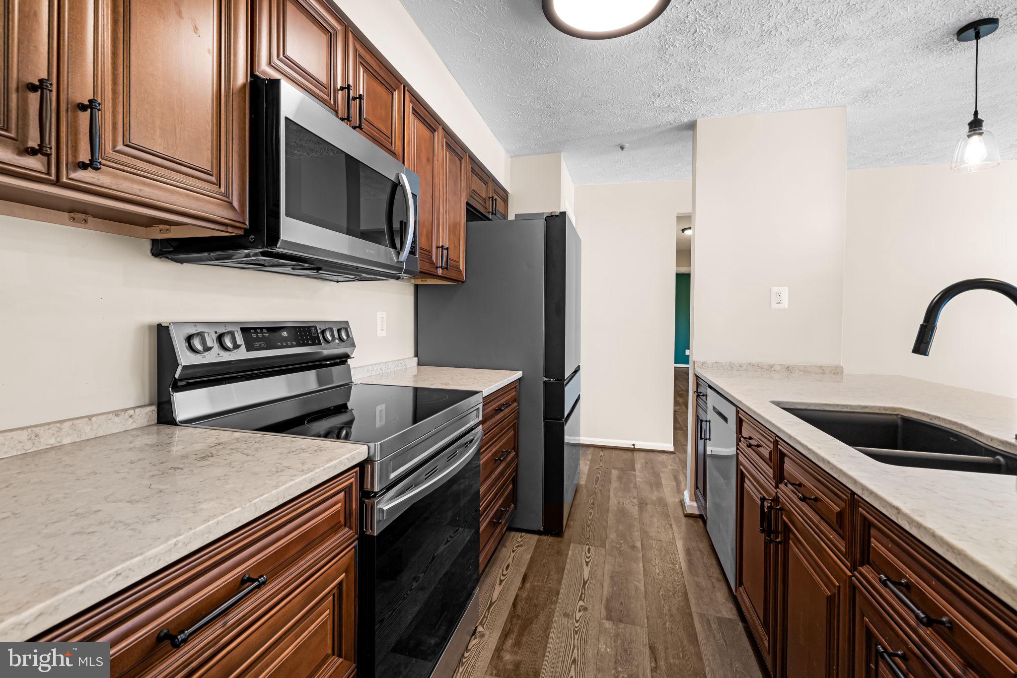 41 Laurel Path Court, Unit 5 Baltimore, MD 21236 - Photo 14 of 32 a kitchen with stainless steel appliances a stove microwave and sink