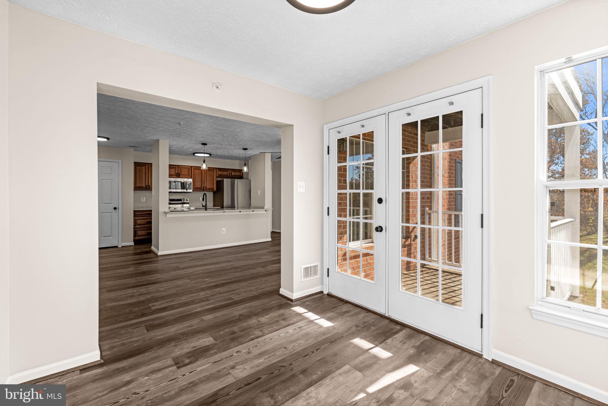 41 Laurel Path Court, Unit 5 Baltimore, MD 21236 - Photo 16 of 32 an empty room with wooden floor and a kitchen
