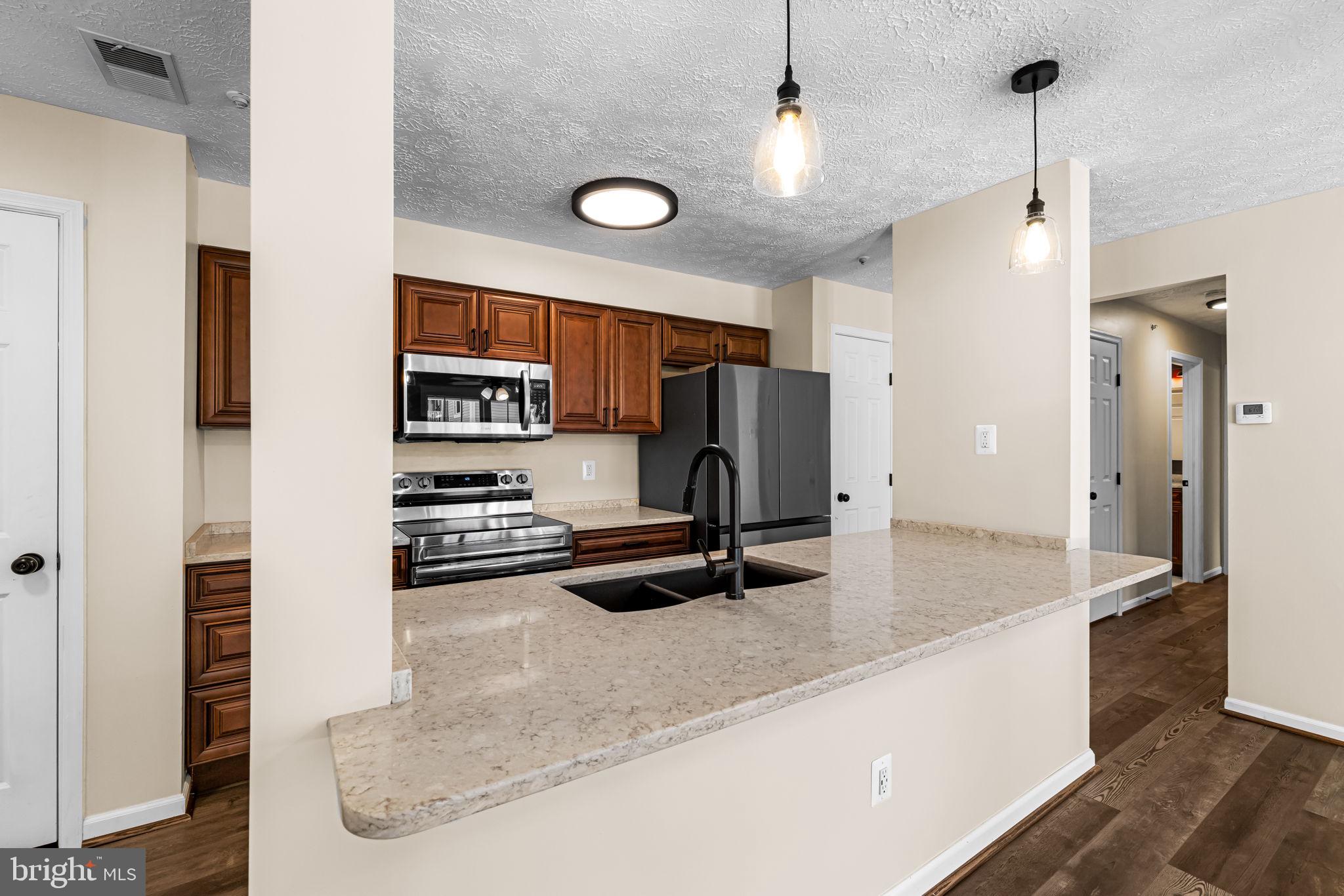 41 Laurel Path Court, Unit 5 Baltimore, MD 21236 - Photo 5 of 32 a kitchen with stainless steel appliances granite countertop a sink a refrigerator and a granite counter tops