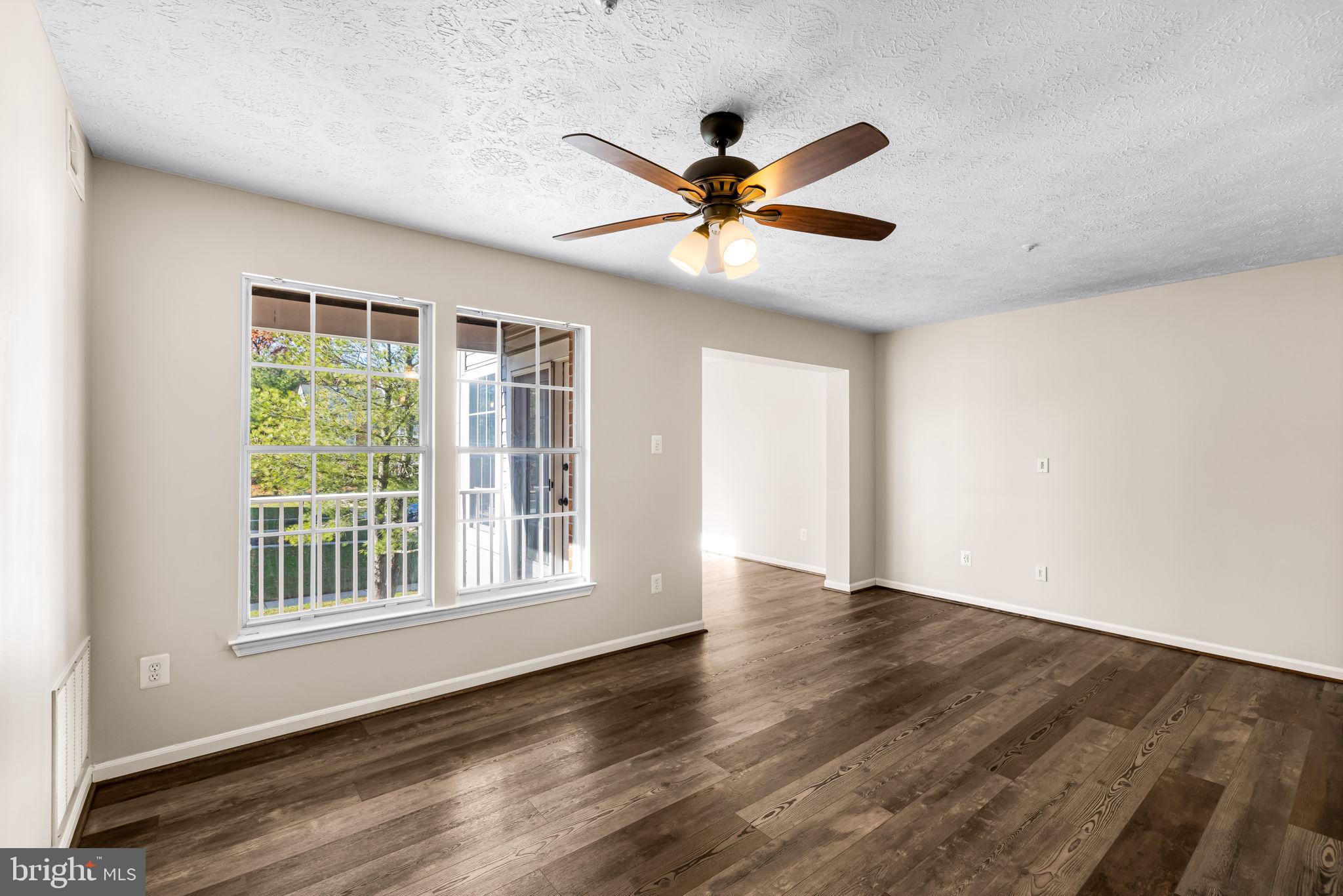 41 Laurel Path Court, Unit 5 Baltimore, MD 21236 - Photo 8 of 32 a view of an empty room with wooden floor and a window