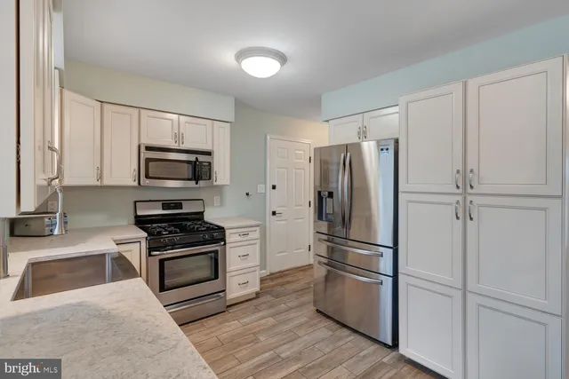 a metallic refrigerator freezer sitting in a kitchen