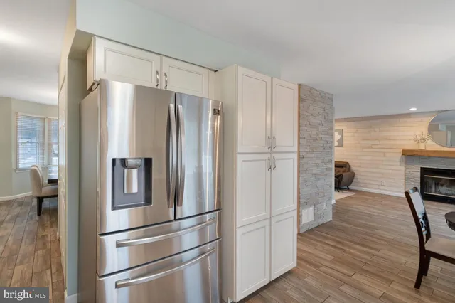 a kitchen with a dining table chairs and white appliances