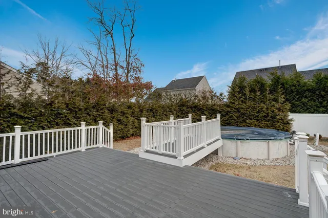a view of a house with wooden deck and trees