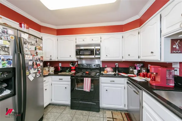 a kitchen with stainless steel appliances a stove a sink and cabinets