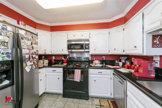 a kitchen with stainless steel appliances a stove a sink and cabinets