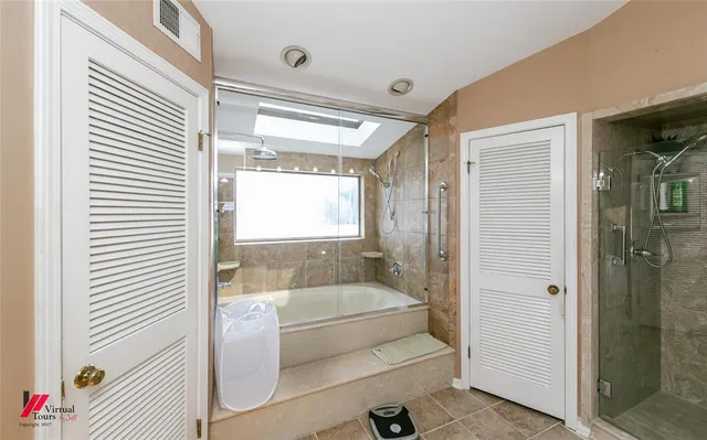 a bathroom with double vanity and a shower