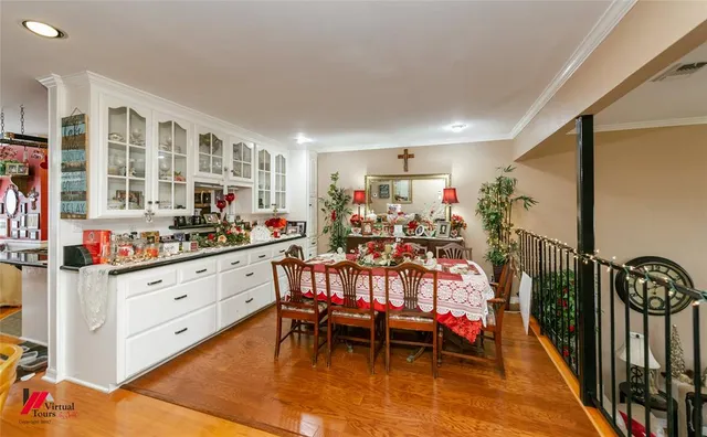 a living room with furniture kitchen view and a wooden floor