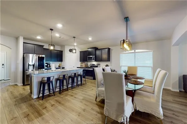 a view of kitchen with kitchen island dining table and stainless steel appliances