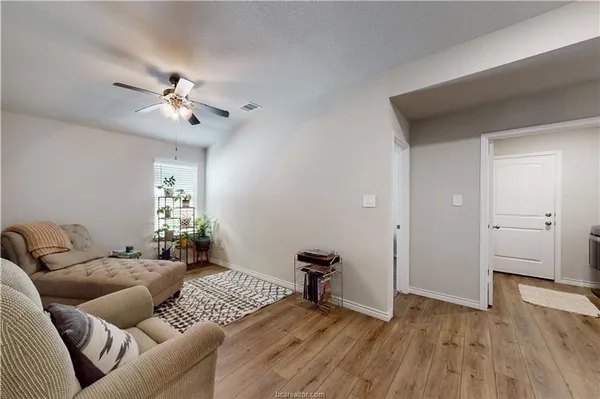 a living room with furniture and a wooden floor