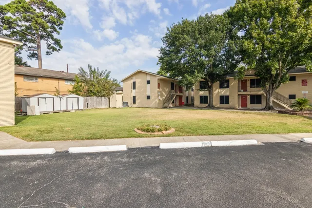 a view of house with yard and large trees