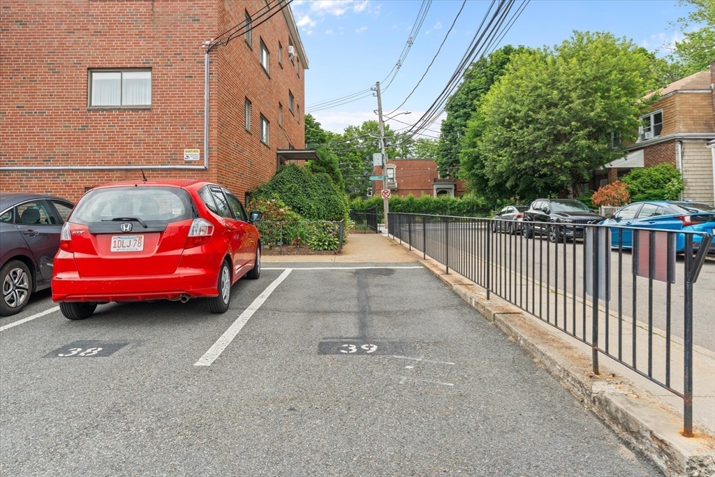 26 Waverly Street, Unit 410 Boston, MA 02135 - Photo 27 of 32 a yellow and red car parked in front of a brick house