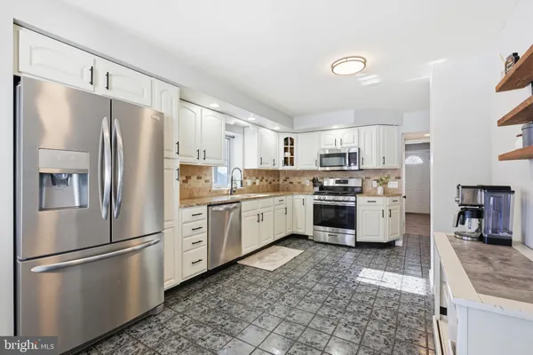 a kitchen with white cabinets and white stainless steel appliances