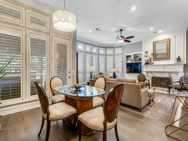a dining room with furniture a chandelier and wooden floor