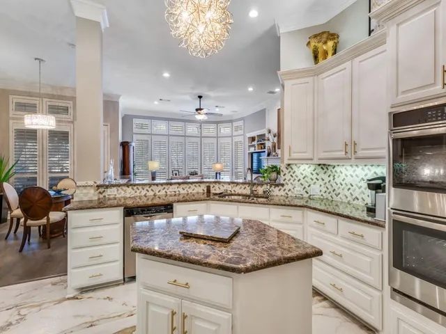 a kitchen with granite countertop a stove a sink and a refrigerator