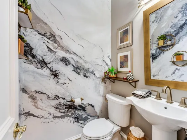 a bathroom with a sink mirror vanity and toilet