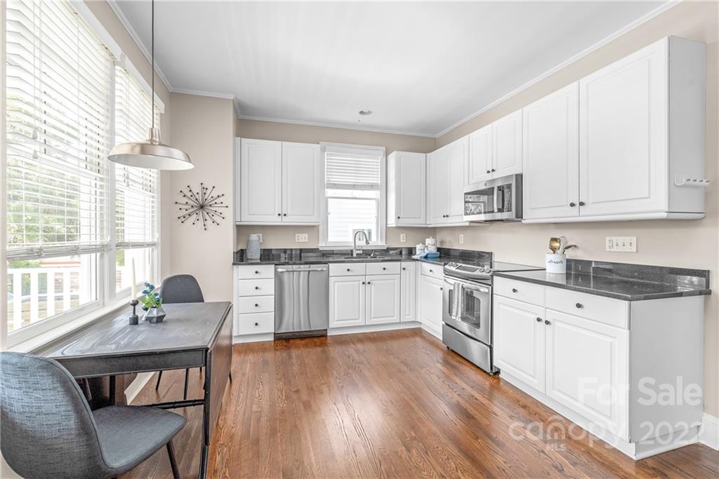 2208 Club Road Charlotte, NC 28205 - Photo 7 of 25 a kitchen with granite countertop white cabinets and wooden floor