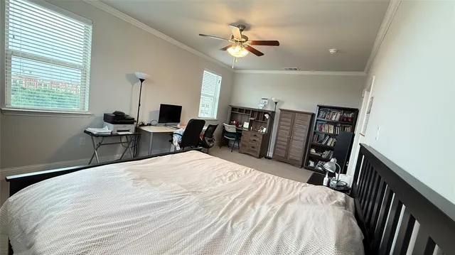 a bedroom with a bed a large window with table and chairs