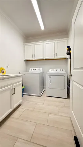 a utility room with cabinets washer and dryer