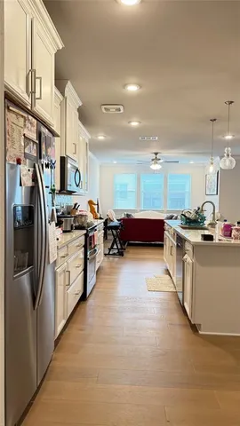 a kitchen with stainless steel appliances kitchen island granite countertop a refrigerator and a stove