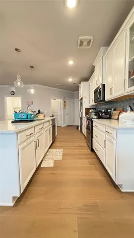 a large kitchen with stainless steel appliances lots of counter space sink and cabinets
