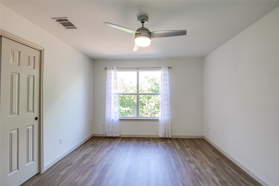 2410 Great Oaks Drive, Unit 804 Round Rock, TX 78681 - Photo 23 of 37 a view of an empty room with wooden floor and a window
