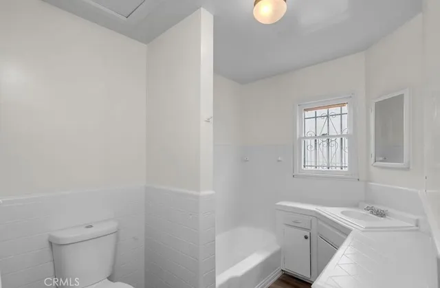 a bathroom with a sink a toilet and window