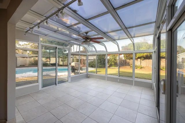an empty room with wooden floor fireplace and windows