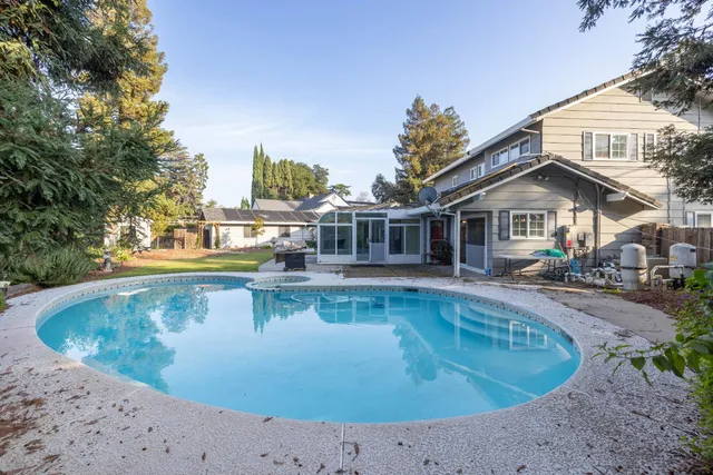 an aerial view of a house with a swimming pool and outdoor seating
