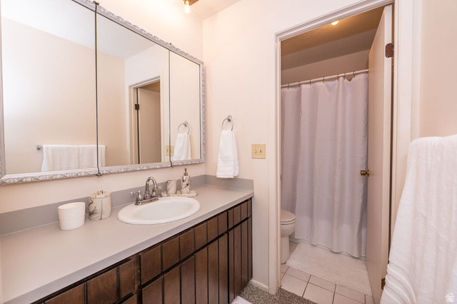 621 Coachman Way Riverdale, UT 84405 - Photo 21 of 38 Primary full bath with a shower with shower curtain, vanity, and new light tile patterned flooring