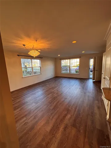 a view of a livingroom with wooden floor and window