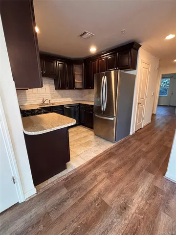 a large kitchen with stainless steel appliances a refrigerator and a sink