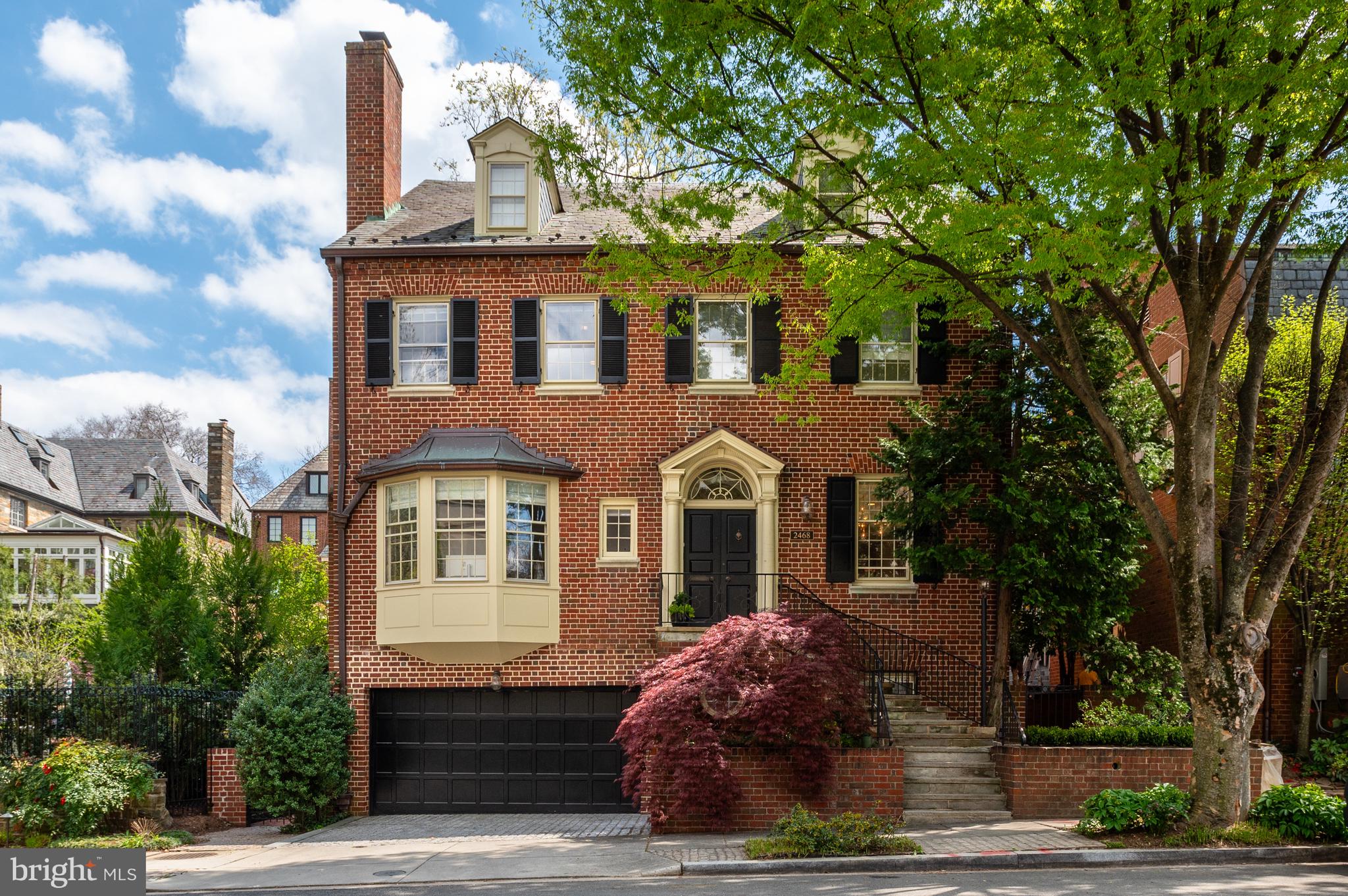 a front view of a house with a tree