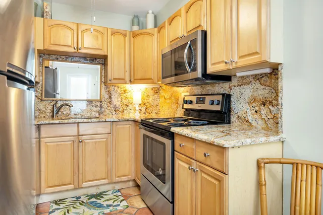 a kitchen with stainless steel appliances granite countertop a stove a sink and a microwave